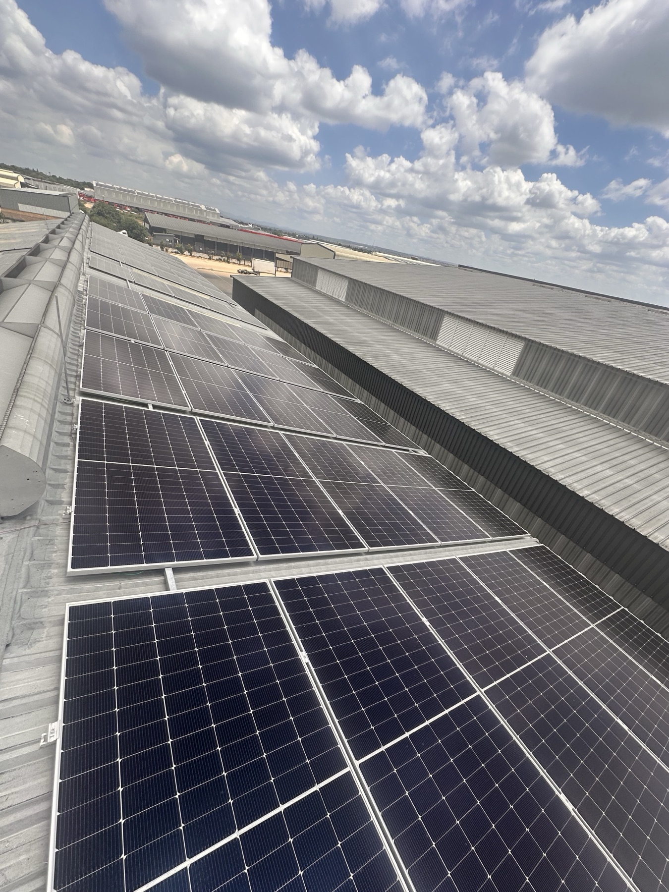 Industrial rooftop solar panels across a factory roof